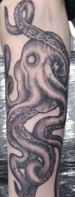 Black and gray octopus tattoo on a forearm.